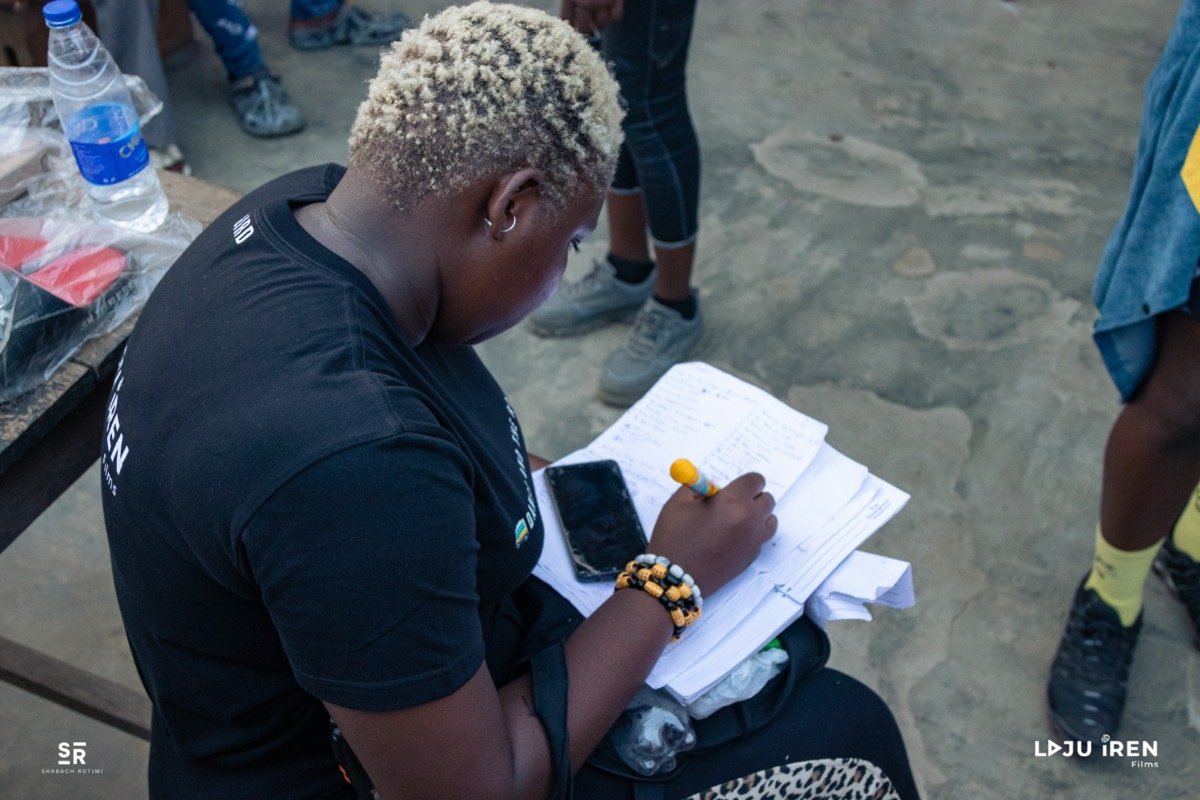 Onome working through the shooting script on set for Laju Iren Films